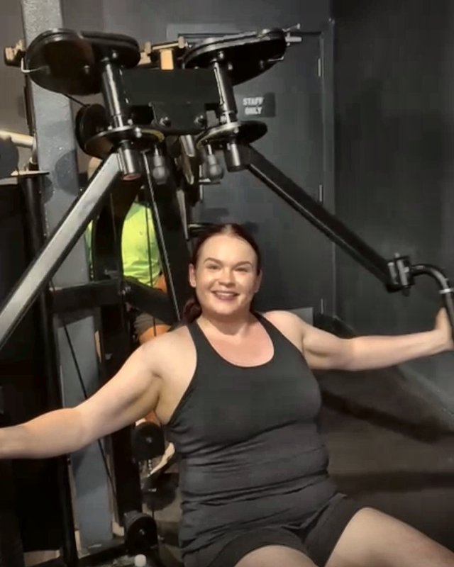 Charlotte smiling on the chest fly machine
