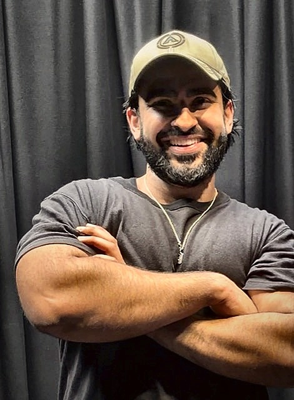 Raja Farrukh, personal trainer, smiling with his arms crossed