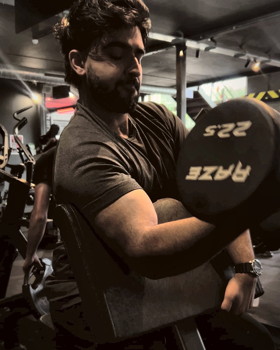 Raja doing preacher curls with a 22.5 kg dumbbell
