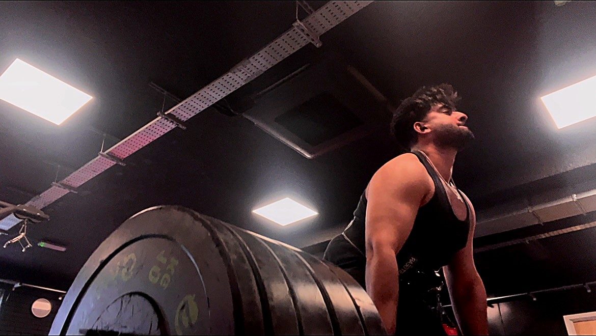 Raja setting up for a heavy deadlift, shot from floor level