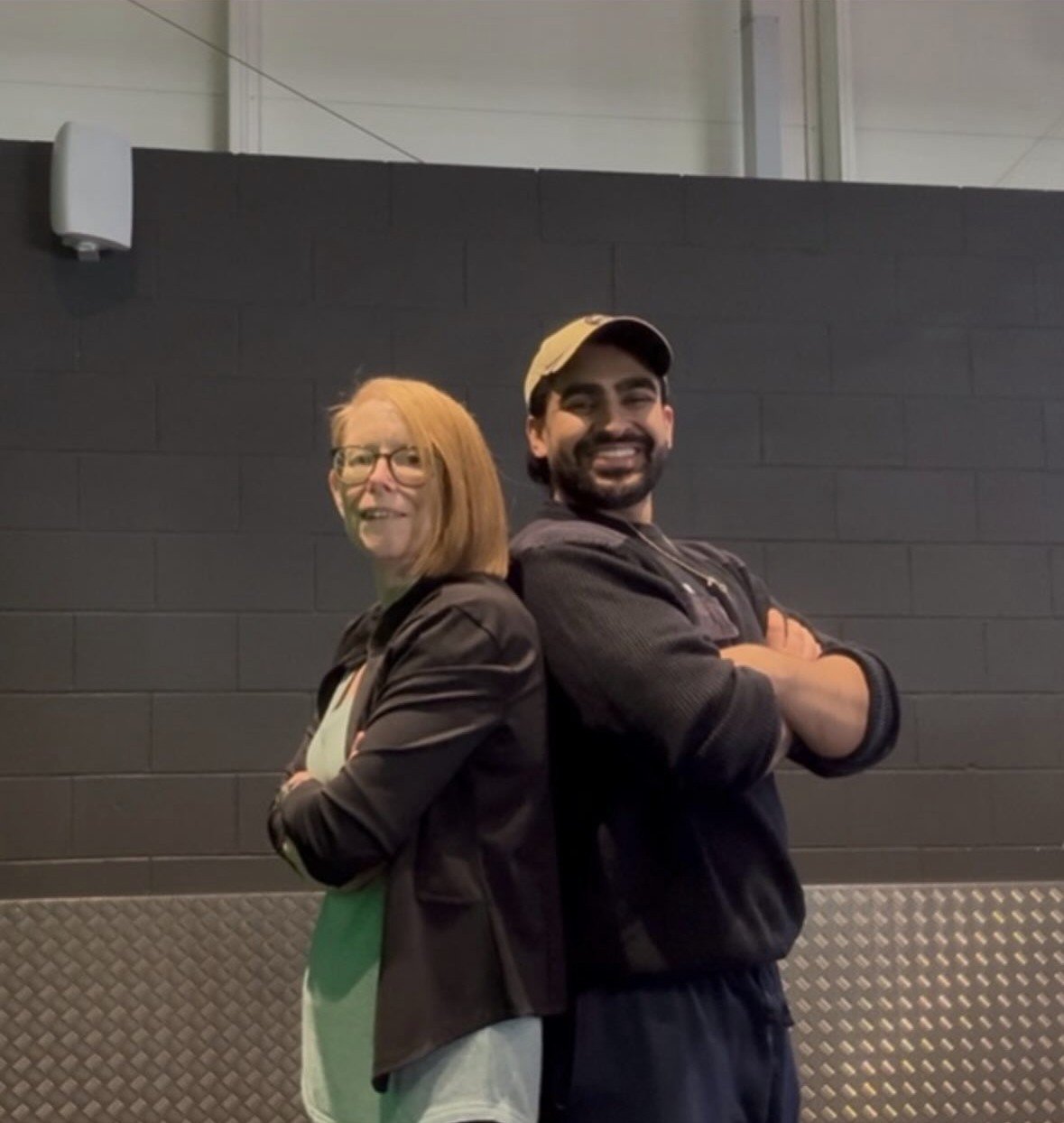Sue and Raja standing back to back with arms crossed